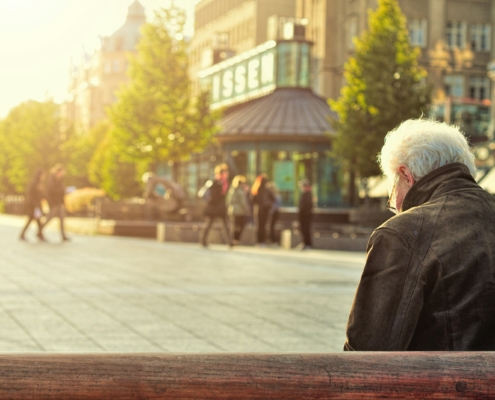 an elderly man sitting on a bench
